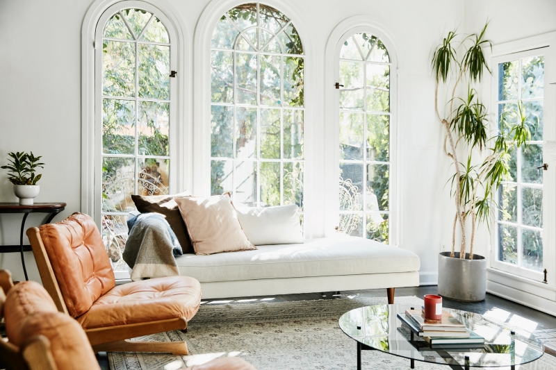 bright living room with large arched windows allowing natural light to fill the space